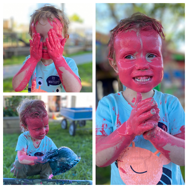 Toddler with face covered in pink poster paint